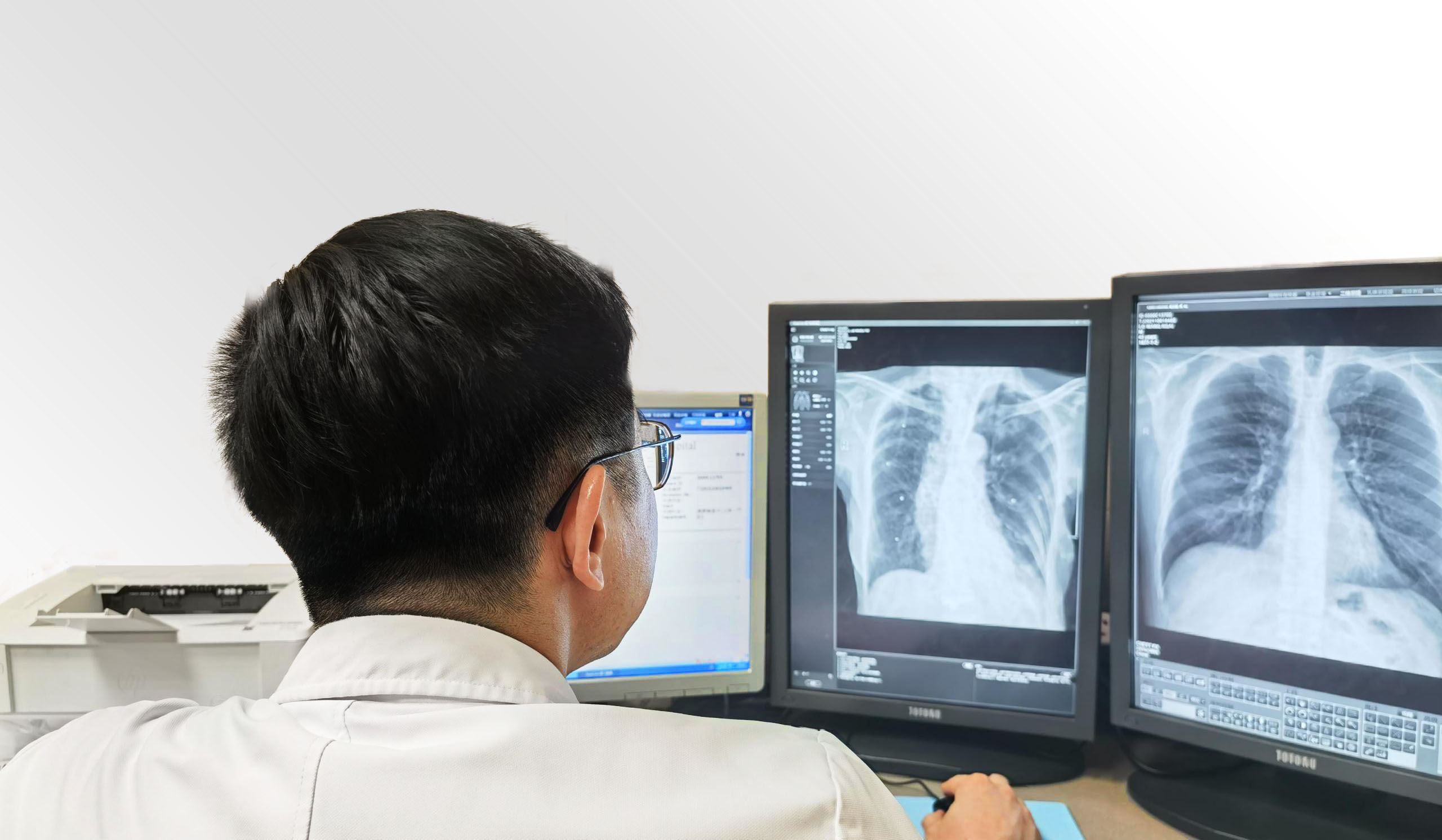 A doctor reading CXR scans using SenseCare-Chest DR Pro diagnostic software.jpg